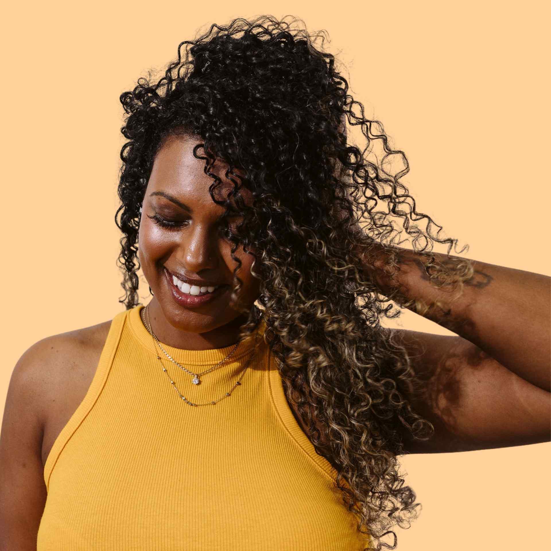 coily haired brunette girl resting on hand with closed eyes