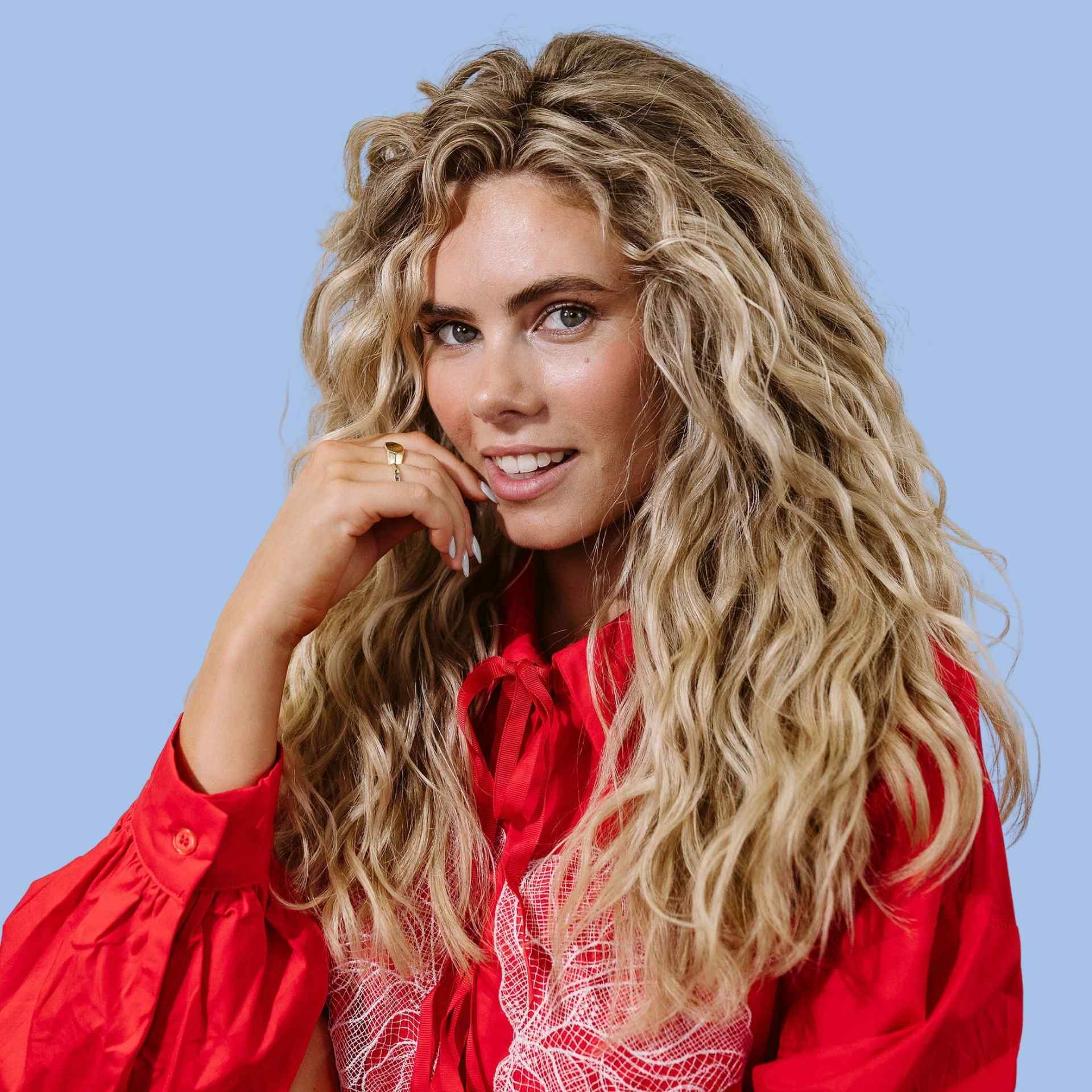 girl with blonde wavy hair staring at camera