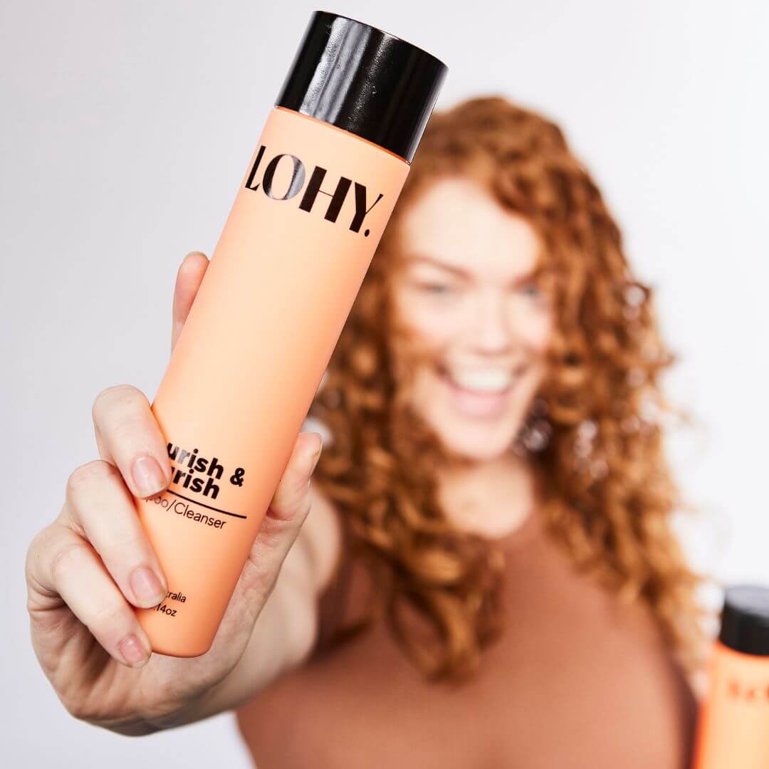 red wavy hair model holding bottle