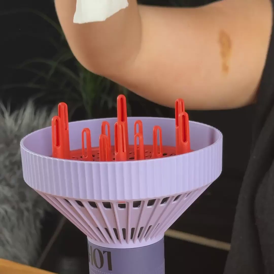 Load video: purple lohy hair diffuser attachment containing tissue with vortex air flow as tissue is dropped onto it
