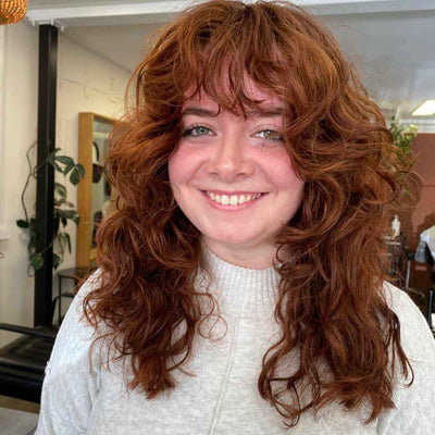 caucasian woman with ginger 2b wavy hair in a shag hairstyle